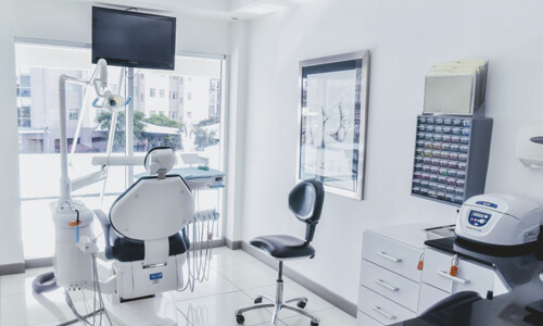 Picture of a dental procedure room representing the dental services of the Costa Rica Dental Center in San Jose, Costa Rica.  The interior is very modern and has primarily white colors.